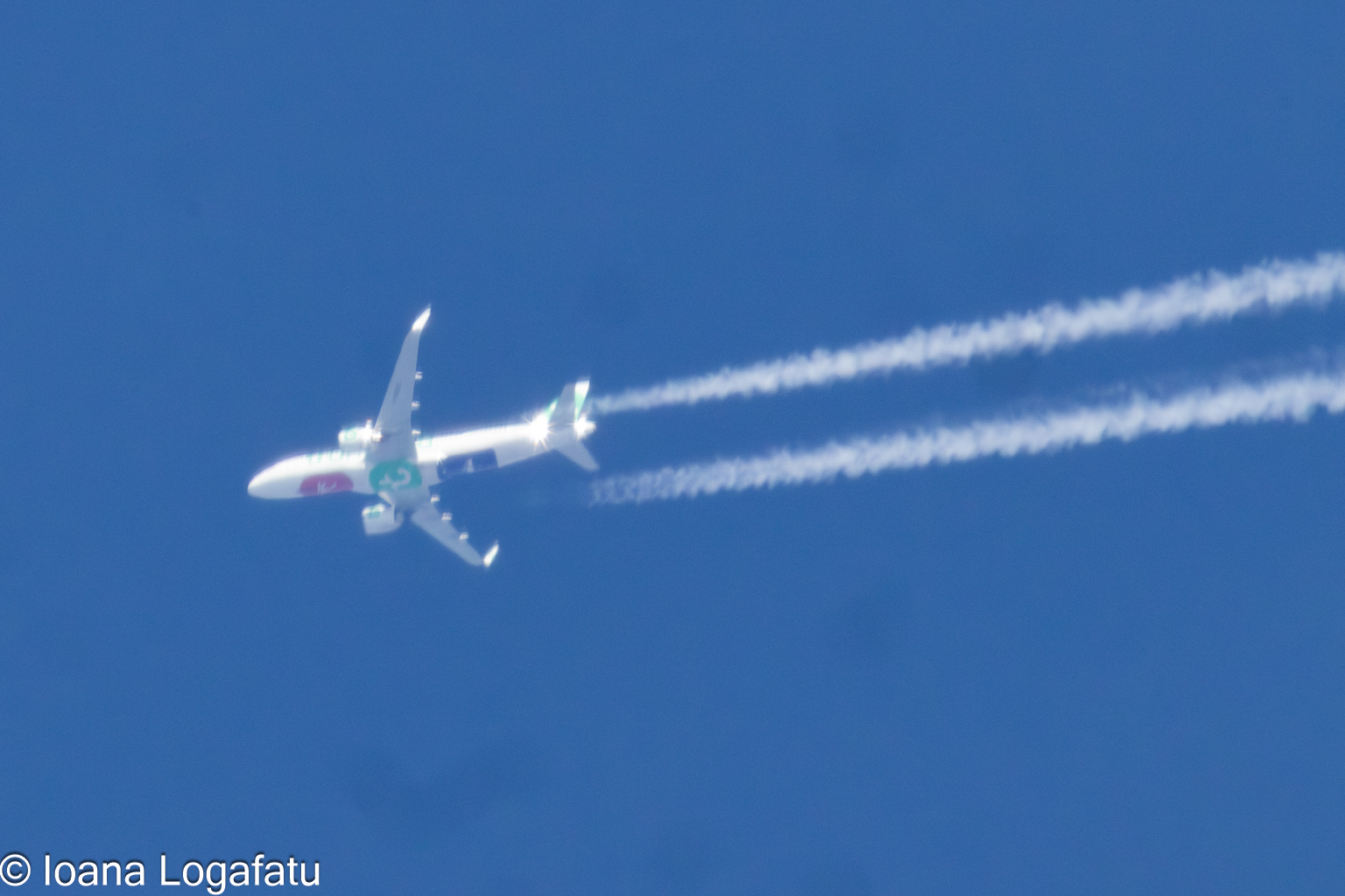 Airplane soaring across a brilliant blue sky